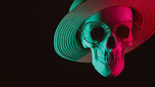 human skull wearing glasses and a hat with colored neon light on a dark background