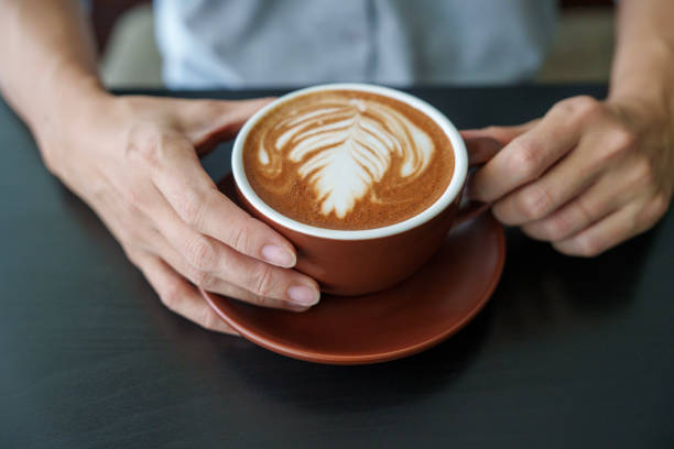 istock High angle view a woman holding a cup of Mocha Latte 2150137678