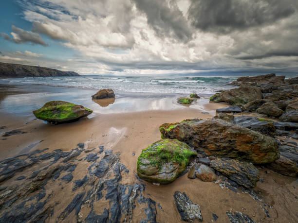 Scene of sandy beach and cliff against cloudy sky at  at Porthtowan, England, Kingdom