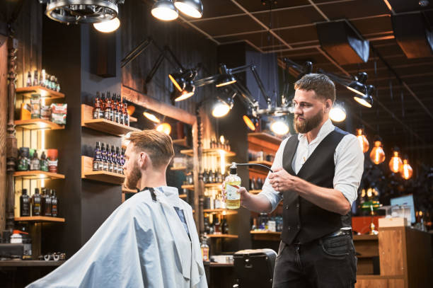 istock Professional barber spraying aftershave lotion on client's nape. 2150140959