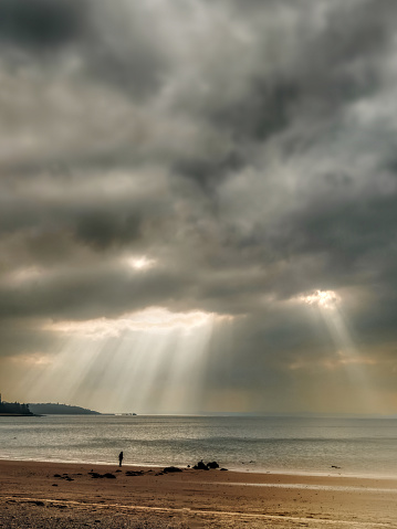Rays of light penetrate the clouds at a Scottish beach.