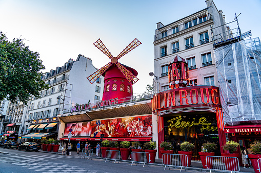 Paris, France. July 6, 2023. Red exterior facade of the mythical and famous cabaret Moulin Rouge located on the boulevard Clichy just outside the Montmartre district of Paris.