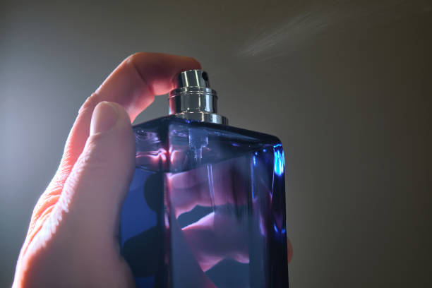 istock Perfume spray in a violet bottle on a dark background. 2150146877