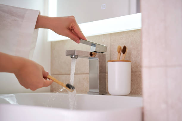 istock Women's hands under running water in the bathroom. Morning routine. 2150147885