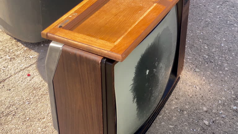 CRT television set abandoned over asphalt