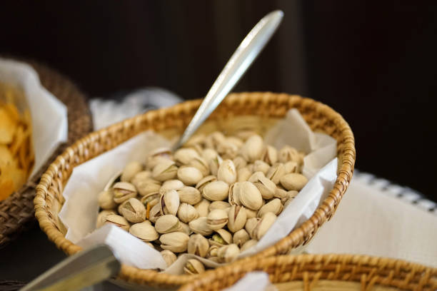 Salted pistachios in a vine basket. Buffet with a salty snack.