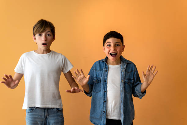 Two children, with raised hands and surprised expressions