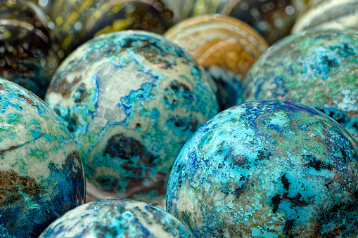 Group of multi-coloured balls made of various natural decorative stones, close-up shot, abstract background