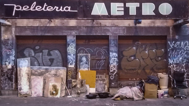 Montevideo, Uruguay - June 16, 2023: Homeless sleeping at street in front of abandoned building, montevideo city, uruguay