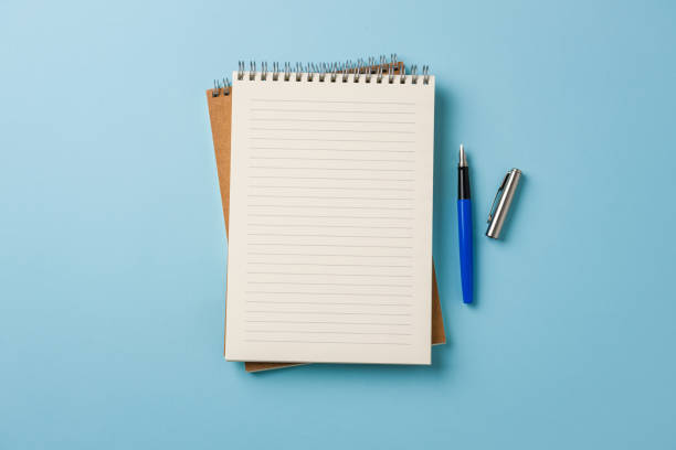 istock Top view of notebook and fountain pen on blue background 2150151386