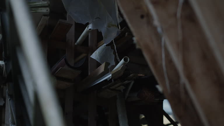 Metal pipe in abandoned property, handheld daytime, filmed through a gap.