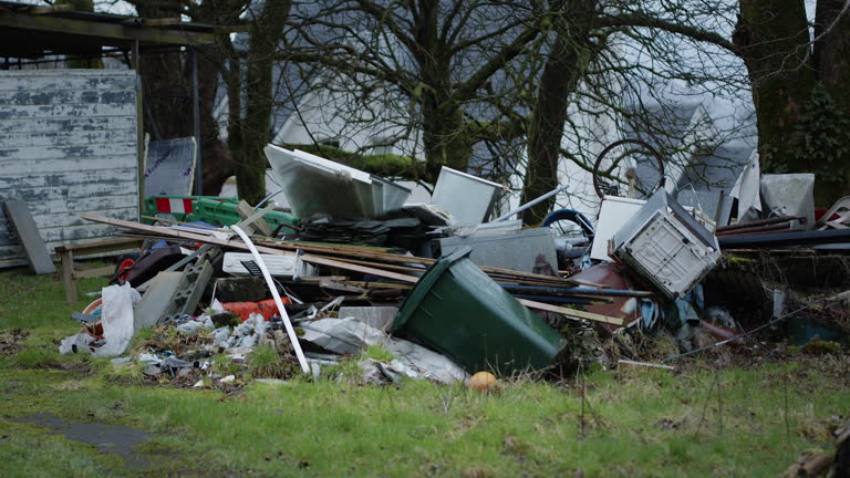 Pile of trash with trees behind. Junk dumped in a pile outside. Handheld footage of pollution in countryside
