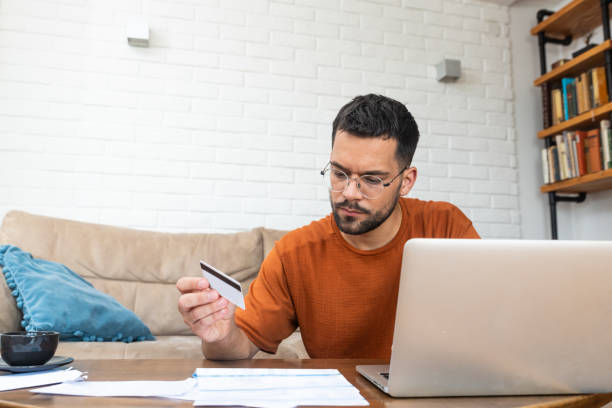 istock Young stressed man having issue with utility bills expense, sitting at home trying to calculate and see bad finance bank report, searching for mistake. College student male with money problem. 2150153059