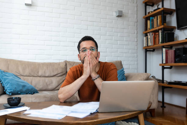 istock Young stressed man having issue with utility bills expense, sitting at home trying to calculate and see bad finance bank report, searching for mistake. College student male with money problem. 2150153062
