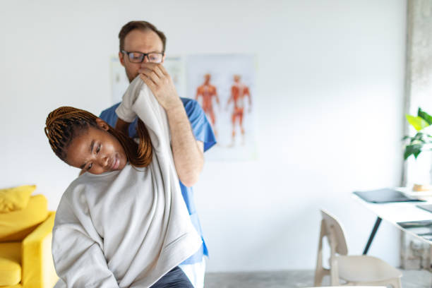 istock Physical therapist helping young black woman with her shoulders 2150155085