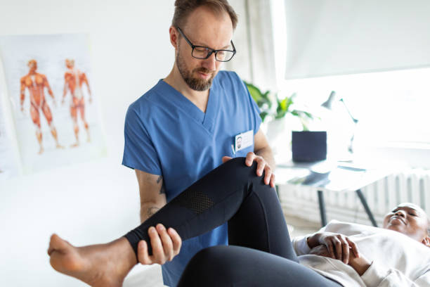istock Physical therapist helping young black woman with her legs 2150155110