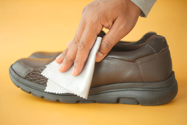 istock Men wipes his leather shoes with a wet cloth 2150157685