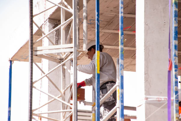 istock Building Construction . A foreman in a helmet works on laying bricks among scaffolding at a height 2150158802