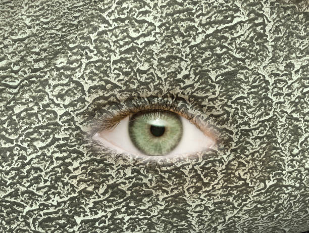 Eye with green pupil in green camouflage background
