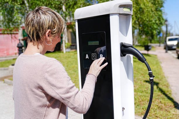 istock Woman at Electric Charging Station Interacting with High-Tech Equipment 2150163040