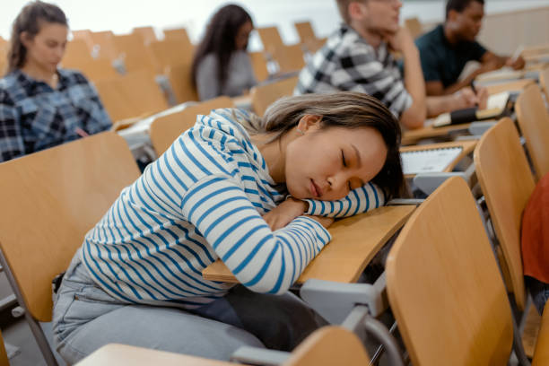 Too lazy to learn today Tired Young Asian Female Student Sleeping in an Auditorium male college student sleeping through lecture stock pictures, royalty-free photos & images