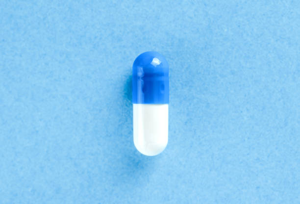 istock White and blue pharmaceutical pill. Medical capsule. Tablet on blue background with copy space. Health concept. 2150163238