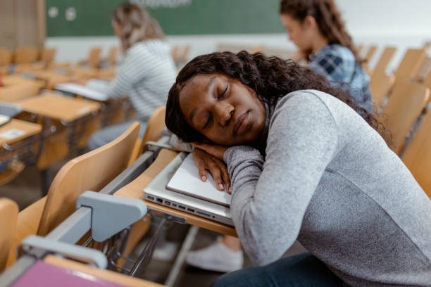 Too lazy to learn today Demotivated African American Student Napping in an Auditorium male college student sleeping through lecture stock pictures, royalty-free photos & images