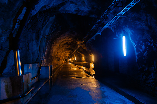 Wet underground  tunnel  illuminated by blue and yellow lights