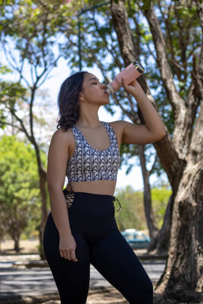 istock woman drinking water in the park 2150167433