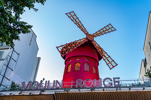 Paris, France. July 6, 2023. Red colored construction of the windmill of the mythical and famous cabaret venue Moulin Rouge located on the boulevard Clichy in the Montmartre district of Paris.
