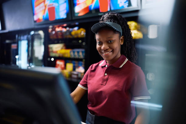 istock Happy black concession stand worker using computer in movie theater. 2150168158