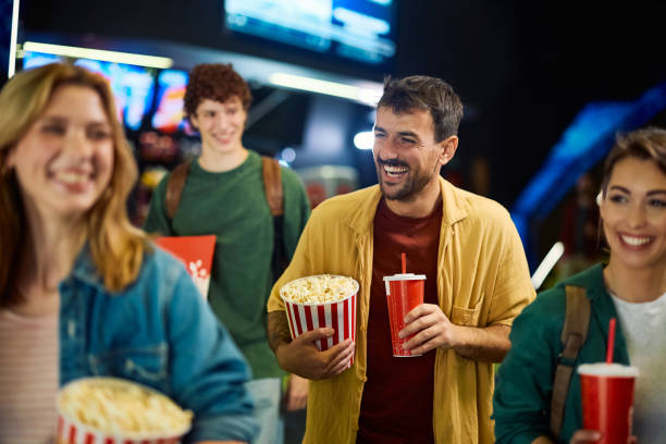 istock Cheerful man having fun while going on movie projection with friends in cinema. 2150168185