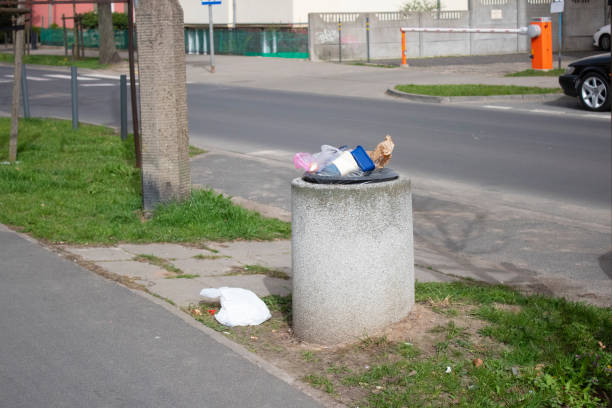 istock Public trash can on a city street filled with garbage 2150168210