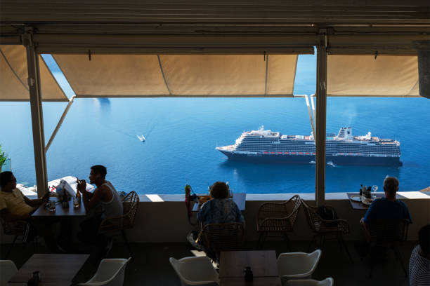 Santorini, Greece - August 16, 2015: Unidentified tourists sitting in traditional Greek taverns on peaceful afternoon in Fira