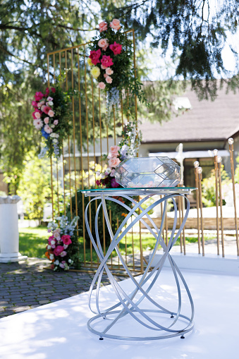 A table with a transparent glass top featuring a bouquet of fresh flowers placed on it.