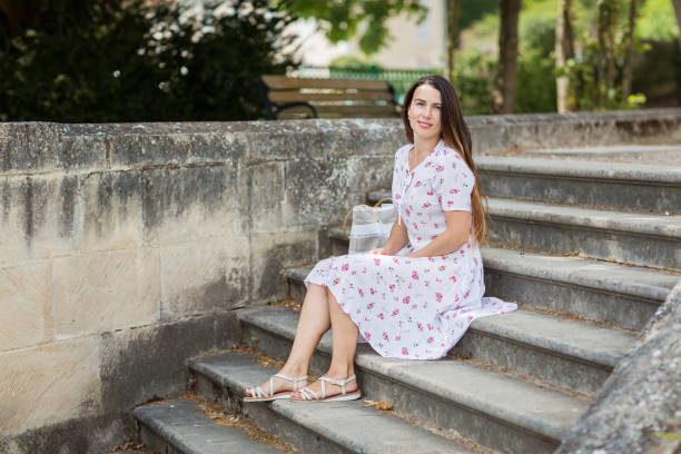 istock Pretty woman sitting and posing on ancient stone stairs 2150170566