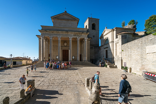 San Marino, San Marino Republic – August 26, 2018: The front view of San Marino cathedral. In the foreground there are gathering a group of tourists.