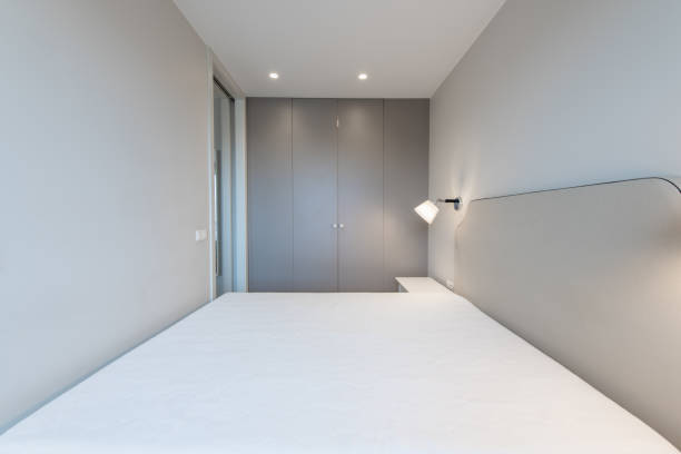 istock Minimalism Bedroom Interior. Wardrobe in Background. Coffee Table and Light 2150170918