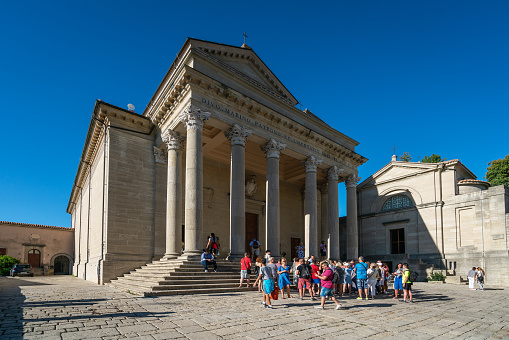 San Marino, San Marino Republic – August 26, 2018: The front view of San Marino cathedral. In the foreground there are gathering a group of tourists.