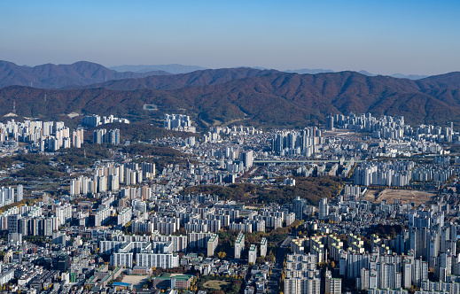 Aerial view from above on a dense residential district full of houses. Mountains in the background.