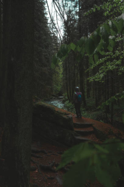 istock Woman in nature, standing over a stream in the rain 2150178270
