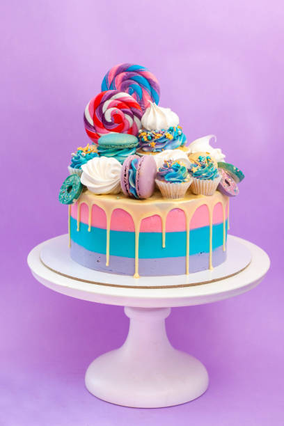 istock Colorful birthday cake with sprinkles, pink, blue and purple deocrations. Plain background, copy space 2150178931