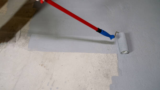 istock A construction worker applies gray epoxy resin in an industrial workshop. An unknown worker uses a long paint roller on the floor. Painting the floor with a roller. 2150181709