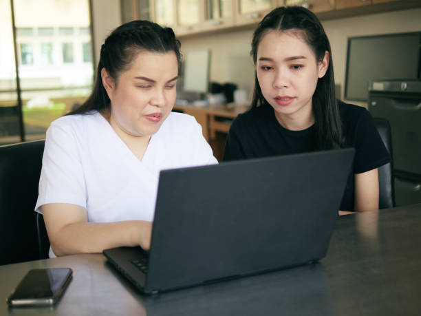 istock Asian women co-workers in workplace including person with blindness disability using laptop computer with screen reader program for visual impairment people. Disability inclusion at work concepts 2150183015