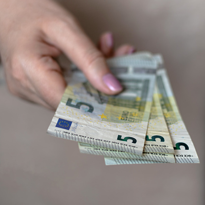Four five euro bills in a woman's hand