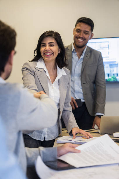 istock Two cheerful real estate agents shaking hands with investor 2150184949