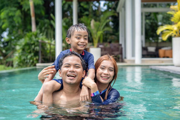 istock Family fun and relaxing in swimming pool 2150185237