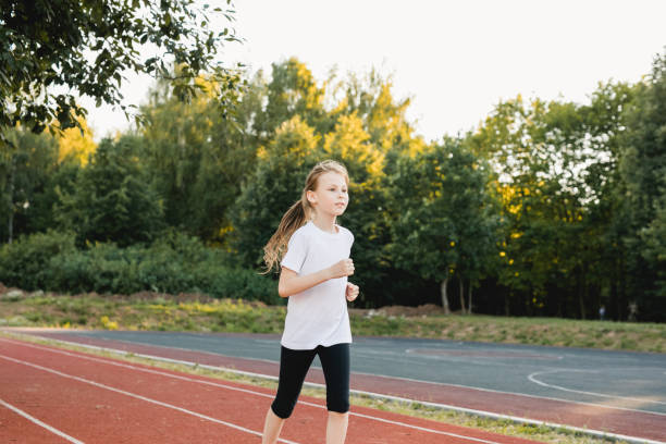 istock Child girl practicing sprinting on running track. ?onfidence, empowerment, teamwork, accomplishment, and healthy physical habits. 2150185500