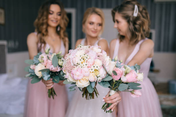 istock girls reach out hands with wedding bouquets 2150187259
