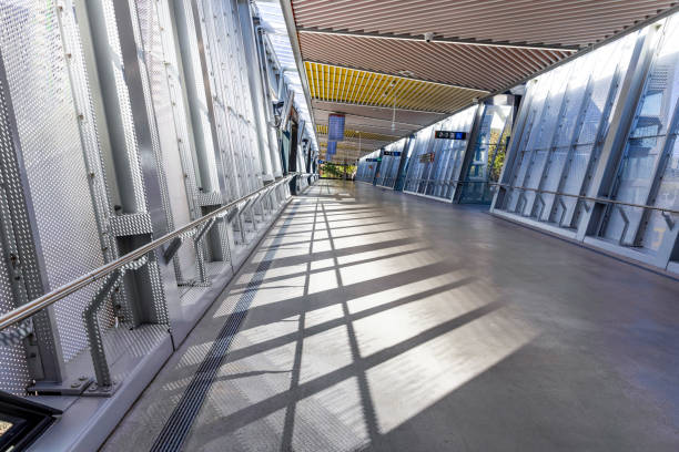 istock Train station modern pedestrian overpass footbridge with sunlight and shade, background with copy space 2150188486